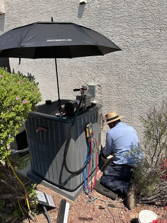 HVAC technician performing outdoor AC maintenance in King