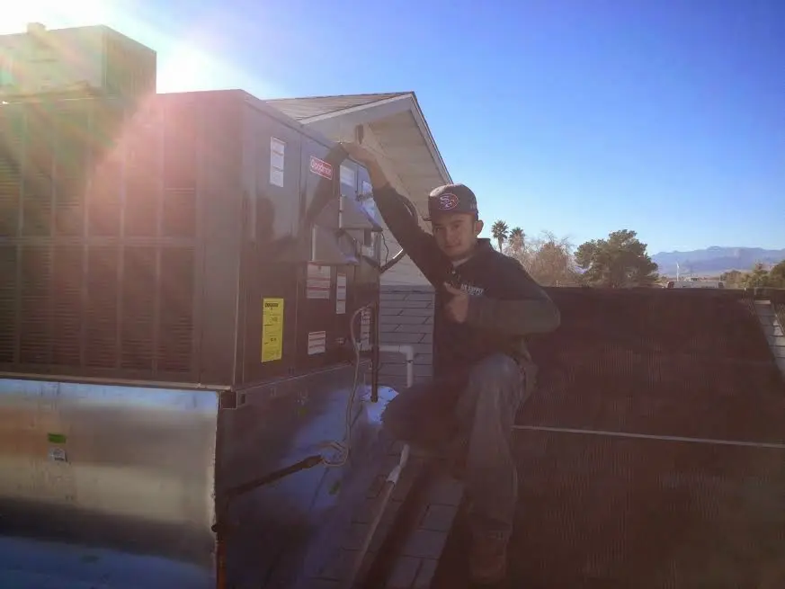 HVAC technician performing Boiler Repair on a rooftop unit in King